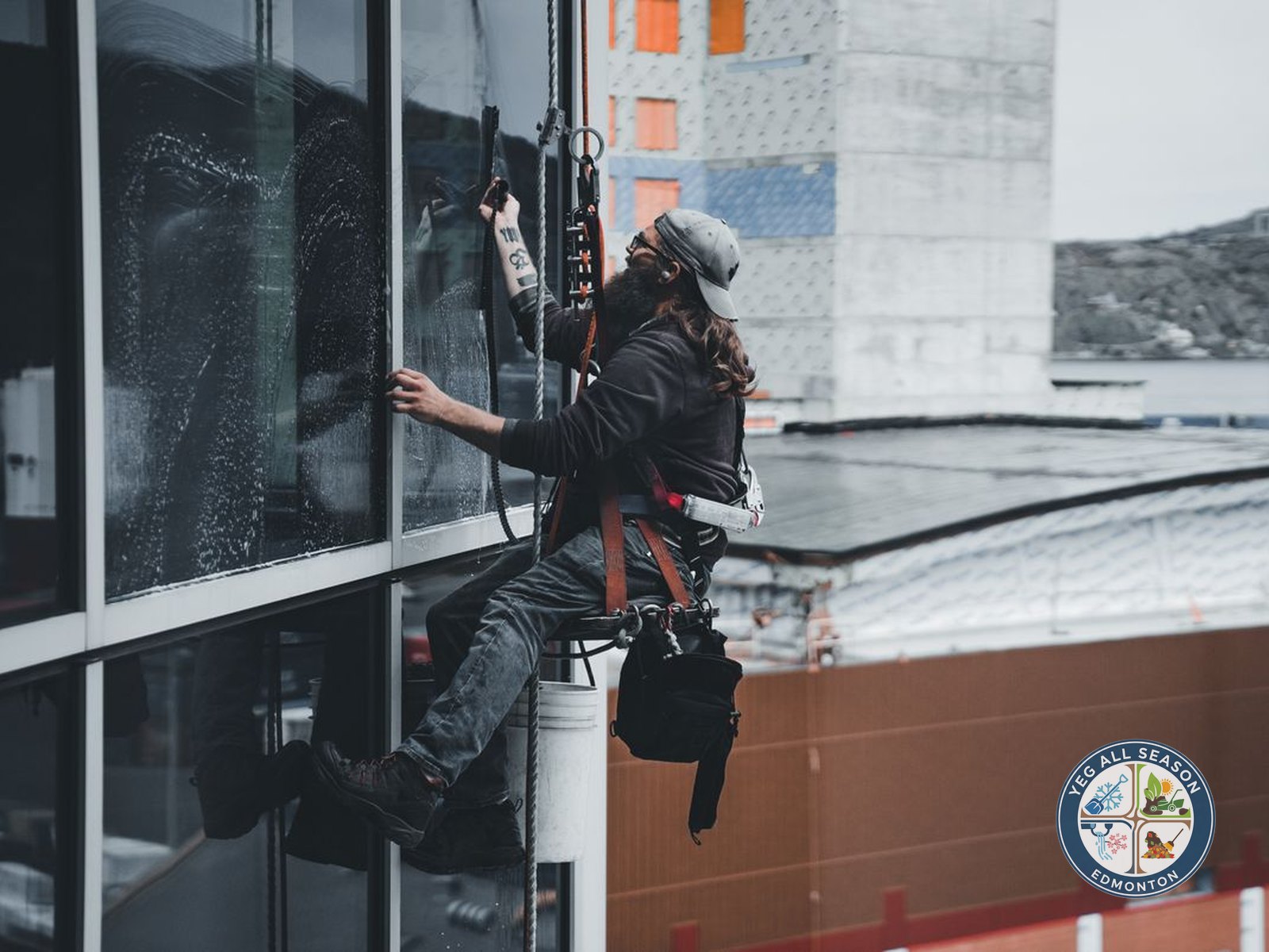 Worker cleaning exterior windows with a squeegee